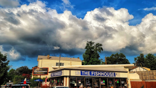 A restaurant called "The Fishhouse" with a cloudy sky above and a sign for a car accident in the background.