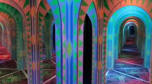 Colorful, abstract arches and patterns create a mesmerizing, infinite hallway effect in a vibrant, mirrored space.