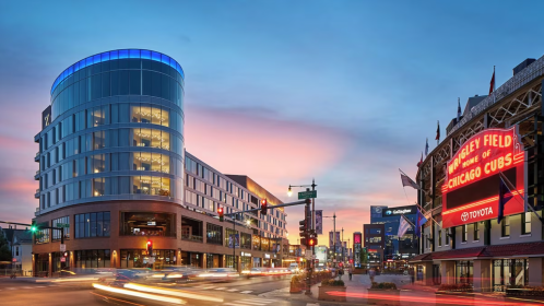 A vibrant sunset over Wrigley Field, showcasing modern buildings and the iconic Cubs sign in Chicago.