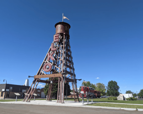 A tall, red and white tower structure with "ELKO" signage against a clear blue sky.