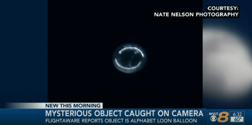 A glowing, circular object in the sky, reported to be an Alphabet Loon balloon, captured on camera.