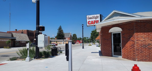 A sunny street view featuring the Coastlight Café and nearby buildings, with clear blue skies above.