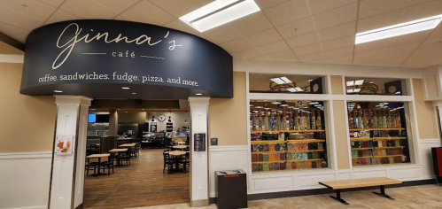 Entrance to Ginna's Café, featuring a sign and a view of seating and decor inside.