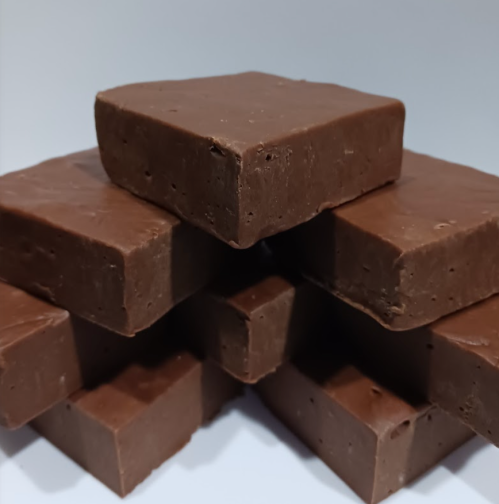 A stack of smooth, rectangular chocolate fudge pieces arranged neatly.