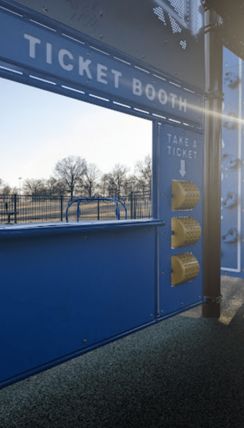 A blue ticket booth with a "Take a Ticket" sign and yellow ticket dispensers, set against a clear sky.