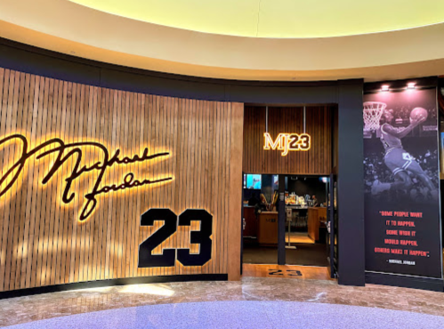 Entrance to a Michael Jordan-themed space featuring his signature and the number 23 on wooden walls.
