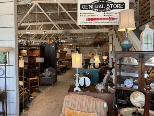 Interior of a general store filled with antiques, collectibles, and home goods, featuring various furniture and decor items.