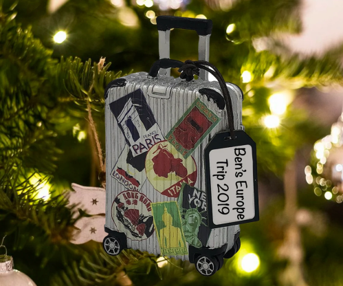 A decorated suitcase with travel stickers and a tag reading "Ben's Europe Trip 2019," set against a festive background.