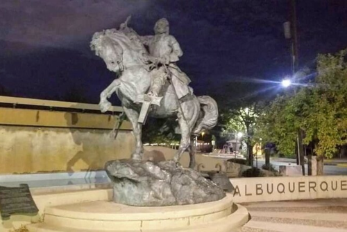 Statue of a mounted figure on horseback, set against a night sky in Albuquerque.