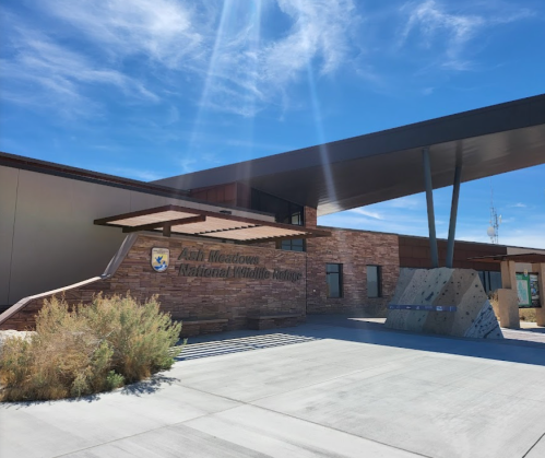 Exterior of Fish Meadows National Wildlife Refuge building with modern architecture and clear blue sky.