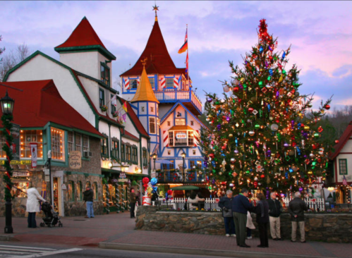 A festive town square with a decorated Christmas tree, colorful buildings, and people enjoying the holiday atmosphere.