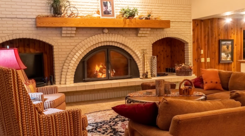 Cozy living room with a fireplace, comfortable seating, and warm lighting, creating a welcoming atmosphere.