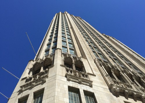 A tall, ornate building with intricate architectural details against a clear blue sky.