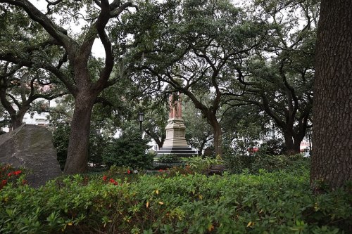 A monument surrounded by lush greenery and trees in a park setting.