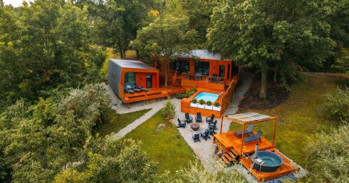 aerial shot of a luxury airbnb cabin surrounded by trees in pleasanton kansas