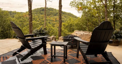 Two chairs sit on a porch overlooking a spectacular view from one of the best cabins in Missouri.