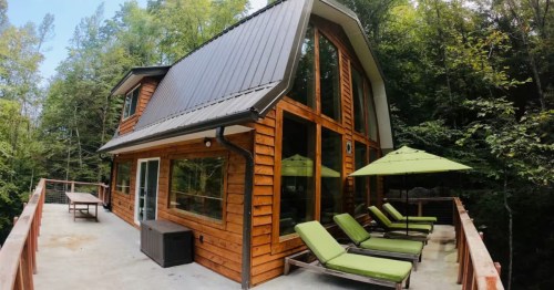 green lounge chairs and a green umbrella out on the deck of a cabin in stanton kentucky