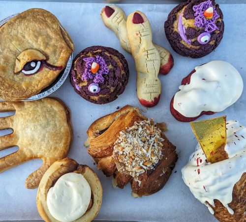 A variety of creatively decorated baked goods, including cookies, pastries, and cupcakes, arranged on a tray.