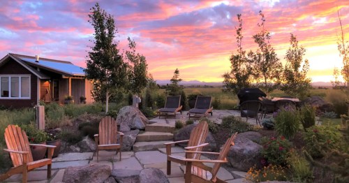 A secluded cabin in Montana with a fire pit at sunset.