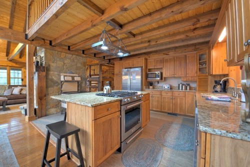 Cozy wooden kitchen with granite countertops, stainless steel appliances, and a spacious island. Warm, rustic decor.