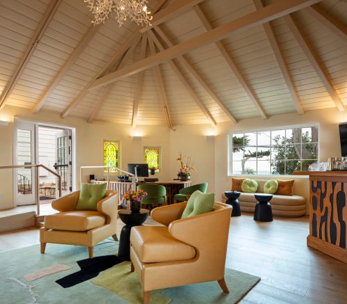 Cozy interior with modern furniture, large windows, and a stylish chandelier in a bright, open space.