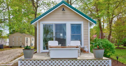 a small cabin with a chairs and a table on a small deck in sussex county, delaware