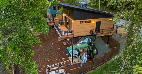 aerial of a cabin on stilts with a hot tub and outdoor seating in Chimney Rock, North Carolina