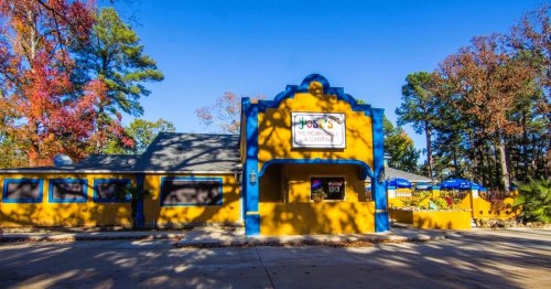 A vibrant yellow building with blue accents, featuring a sign for "Joe's Mexican Cantina" and outdoor seating.