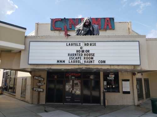 A cinema marquee displays "Laurel's House of Horror" and promotes a haunted house escape room.