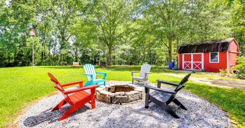 Colorful Adirondack chairs sit on a patio, overlooking a grassy area in the small town of Glen, MS.