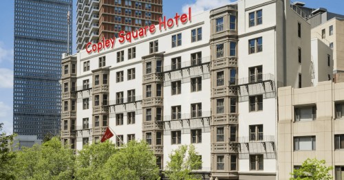 Exterior view of Copley Square Hotel, featuring a modern design and greenery in the foreground.