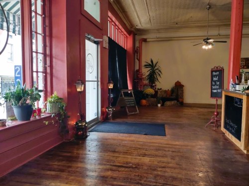 A spacious, warmly lit entryway with wooden floors, plants, and a welcoming atmosphere.