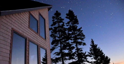 views of a cabin in Machiasport, Maine against a star-filled sky