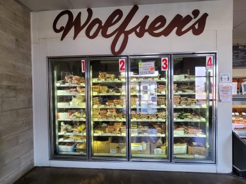 A display case at Wolfsen's filled with various packaged meats and sausages, labeled with numbers 1 to 4.