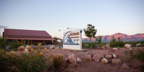 A building with a sign reading "Sky Islands" surrounded by desert landscape and mountains in the background.