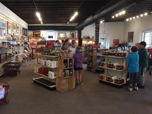 A spacious store interior with shelves of products, customers browsing, and displays of jars and bottles.
