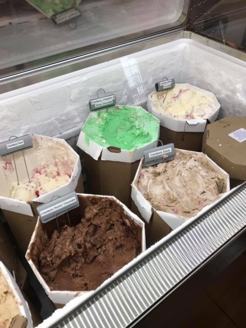 A display of various ice cream flavors in octagonal containers, including chocolate, mint, and strawberry.