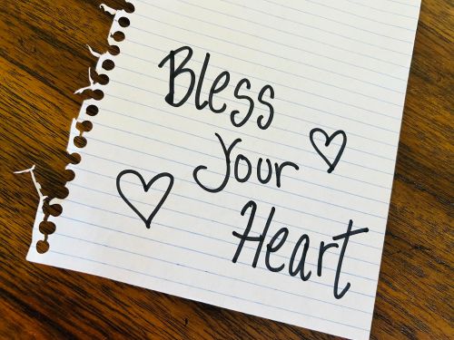 Handwritten note on lined paper that says "Bless Your Heart" with two hearts drawn.