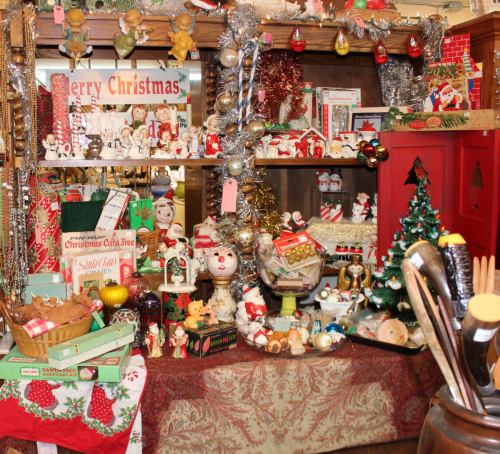 A festive display of vintage Christmas decorations, including ornaments, figurines, and holiday-themed items.