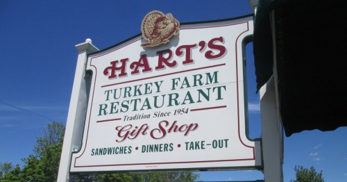 Sign for Hart's Turkey Farm Restaurant, featuring "Gift Shop" and offerings like sandwiches, dinners, and take-out.