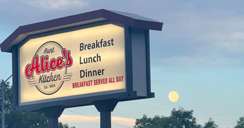 Sign for Aunt Alice's Kitchen advertising breakfast, lunch, and dinner, with a full moon in the background.
