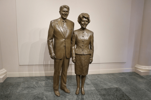 Bronze statue of Ronald and Nancy Reagan standing side by side, dressed in formal attire.