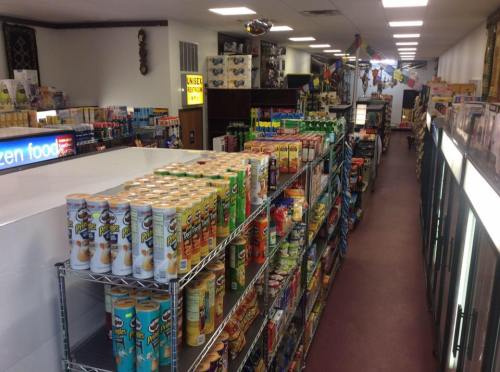 A grocery store aisle filled with shelves of snacks, drinks, and various food items, with a bright, organized layout.