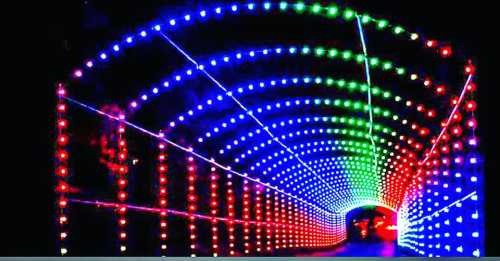 A colorful illuminated tunnel with red, green, and blue lights creating a vibrant, festive atmosphere.