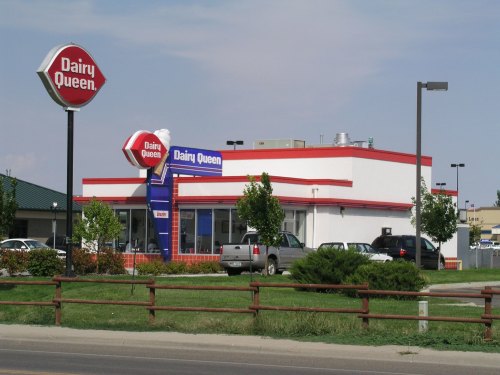 A Dairy Queen restaurant with a red and white exterior, featuring a large sign and a drive-thru area.
