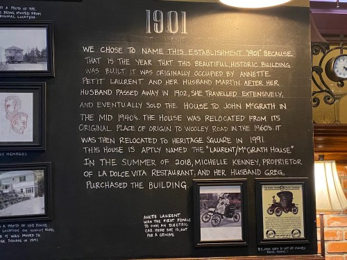 Text on a wall explaining the history of the establishment named "1901," including past occupants and relocations.