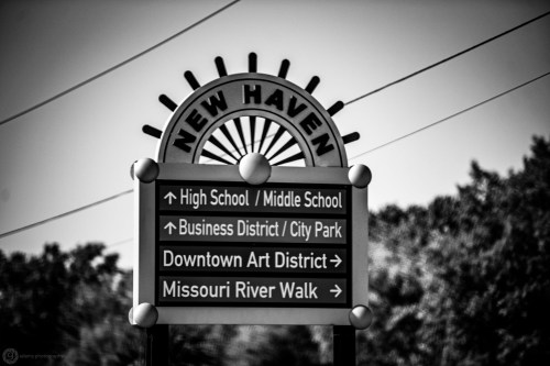 Signpost for New Haven with directional arrows for local schools, business district, parks, art district, and river walk.