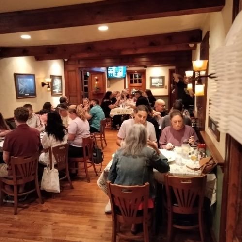 A busy restaurant interior with diners at tables, enjoying meals and conversation in a warm, inviting atmosphere.