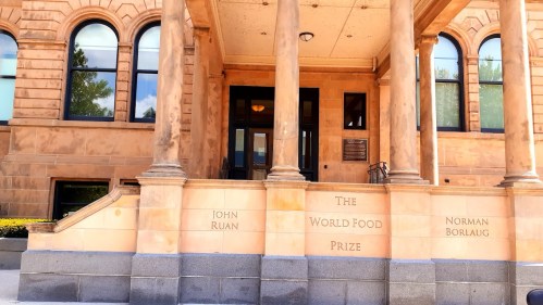 Entrance of the World Food Prize building, featuring columns and engraved names: John Ruan and Norman Borlaug.