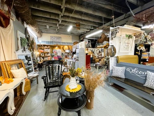 A cozy antique shop filled with vintage furniture, decor, and warm lighting, creating an inviting atmosphere.